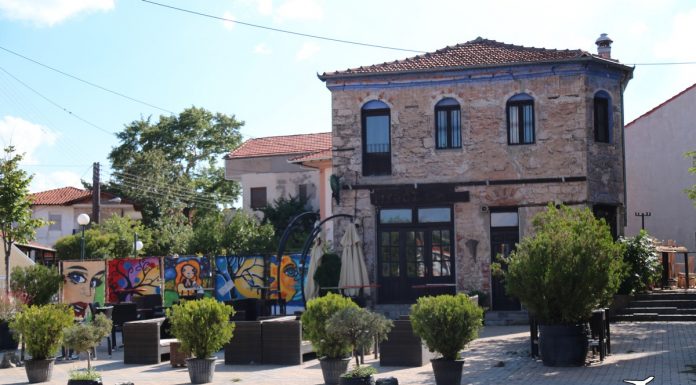 Το κεντρικό σημείο του χωριού Ξινό Νερό, με πλακόστρωτο δρόμο και πέτρινα κτίρια.