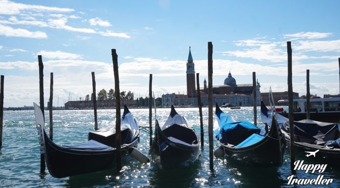 Γόνδολες πλέουν σε κανάλι της Βενετίας με φόντο παλιά βενετσιάνικα κτίρια.