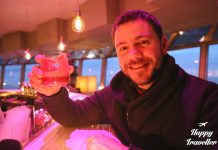 ο ευτύχης στο εστιατόριο ufo στη μπρατισλάβα κρατώντας ποτήρι για τσιν τσιν με θέα στον δούναβη