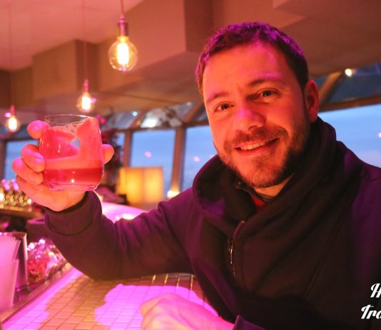 ο ευτύχης στο εστιατόριο ufo στη μπρατισλάβα κρατώντας ποτήρι για τσιν τσιν με θέα στον δούναβη