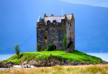 Happy Traveller στην Σκωτία (Μέρος Α) | Ολόκληρο επεισόδιο Το Castle Stalker, ένα επιβλητικό μεσαιωνικό κάστρο χτισμένο σε νησάκι μέσα σε λίμνη στη Σκωτία, με καταπράσινο τοπίο γύρω του.