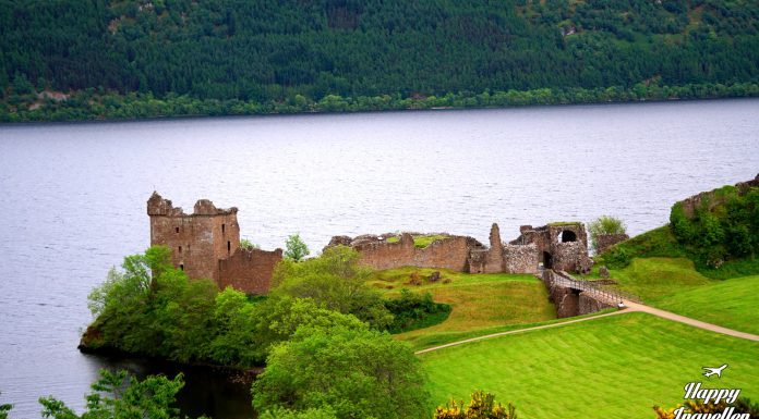 Το Urquhart Castle δεσπόζει στις όχθες της λίμνης Loch Ness στη Σκωτία, με τα ιστορικά ερείπια και τη λίμνη στο φόντο.