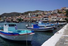 Ταξιδιωτικός οδηγός για τη Σάμο: Εξερευνώντας το Καρλόβασι και το Πυθαγόρειο Πολύχρωμες βάρκες δεμένες στο λιμάνι του Πυθαγορείου στη Σάμο, με γαλήνια νερά και παραδοσιακά σπίτια στο βάθος.