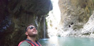 Ο Ευτύχης Μπλέτσας σε στάση ράφτινγκ στον ποταμό Άραχθο, με φόντο το καταπράσινο τοπίο των Τζουμέρκων.