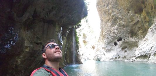Ο Ευτύχης Μπλέτσας σε στάση ράφτινγκ στον ποταμό Άραχθο, με φόντο το καταπράσινο τοπίο των Τζουμέρκων.