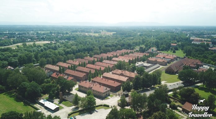 Εναέρια λήψη με drone του στρατοπέδου Άουσβιτς, με θέα τις εγκαταστάσεις και τις σειρές από κτίρια, περιβαλλόμενα από συρματοπλέγματα.