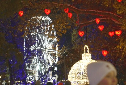 Χριστουγεννιάτικη Βιέννη φωτισμένη το βράδυ, με στολισμένους δρόμους, λαμπερά δέντρα και γιορτινή διακόσμηση σε ιστορικά κτίρια.