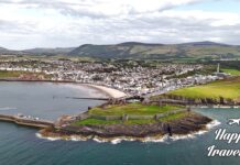 10 άγνωστα πράγματα για το Isle of Man Αεροφωτογραφία του Isle of Man, που δείχνει τις καταπράσινες πλαγιές, τις παραλίες και τις ακτές του νησιού, με το μπλε της θάλασσας να αγκαλιάζει τη γη.