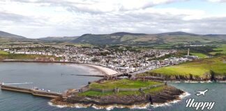 Αεροφωτογραφία του Isle of Man, που δείχνει τις καταπράσινες πλαγιές, τις παραλίες και τις ακτές του νησιού, με το μπλε της θάλασσας να αγκαλιάζει τη γη.