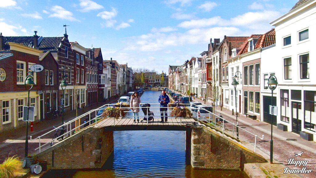 Η οικογένεια πάνω σε γέφυρα στο Άμστερνταμ, απολαμβάνοντας τη θέα της πόλης.