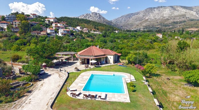 Τοπικό αγρόκτημα στα Καρδάμυλα της Χίου με καταπράσινα χωράφια, παραδοσιακά κτίσματα και λουλούδια.
