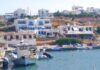 Παραδοσιακά καΐκια δεμένα στο γραφικό λιμάνι των Λειψών, με γαλήνια νερά και το χωριό στο βάθος.