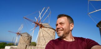 Ο Ευτύχης στο γραφικό τοπίο με τους ανεμόμυλους της Πάτμου, με θέα το Αιγαίο.