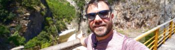 Ευτύχης στέκεται σε μονοπάτι στο Καρπενήσι με φόντο τα πυκνά φθινοπωρινά δάση και τα βουνά της Ευρυτανίας.