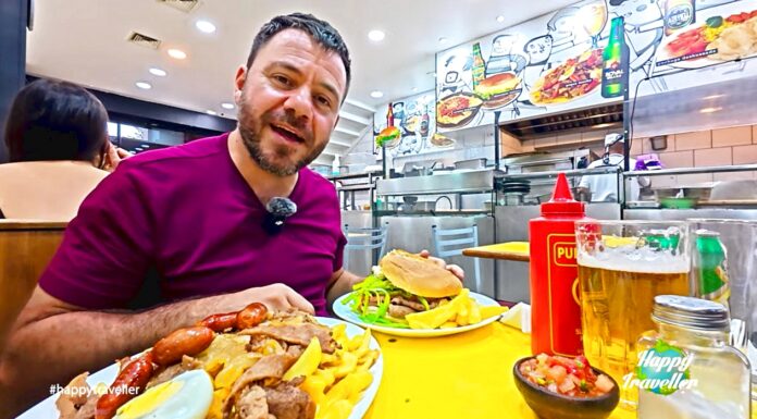 Ο Ευτύχης μέσα σε εστιατόριο στο Σαντιάγο της Χιλής δοκιμάζει το παραδοσιακό σάντουιτς Chacarero και το πιάτο pique macho με πατάτες, κρέας, αυγό και λουκάνικα.