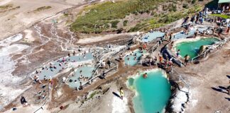 Πανοραμική θέα των Termas de Colina στις Άνδεις της Χιλής με φυσικές θερμές πισίνες σε πετρόχτιστες βαθμίδες και ορεινό τοπίο γύρω.