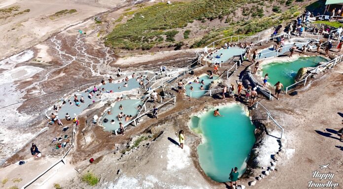 Πανοραμική θέα των Termas de Colina στις Άνδεις της Χιλής με φυσικές θερμές πισίνες σε πετρόχτιστες βαθμίδες και ορεινό τοπίο γύρω.