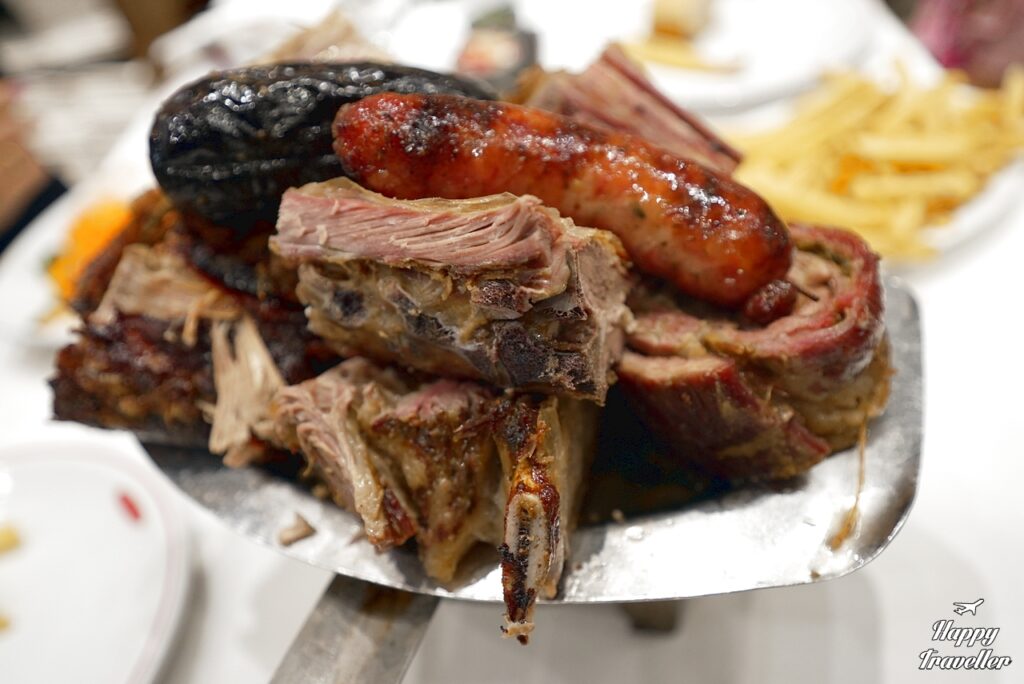 Παραδοσιακό ασάδο σερβιρισμένο στο πιάτο, με ποικιλία από κομμάτια κρέατος.