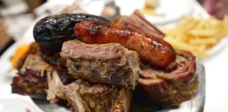 Παραδοσιακό ασάδο σερβιρισμένο στο πιάτο, με ποικιλία από κομμάτια κρέατος.