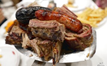 Παραδοσιακό ασάδο σερβιρισμένο στο πιάτο, με ποικιλία από κομμάτια κρέατος.